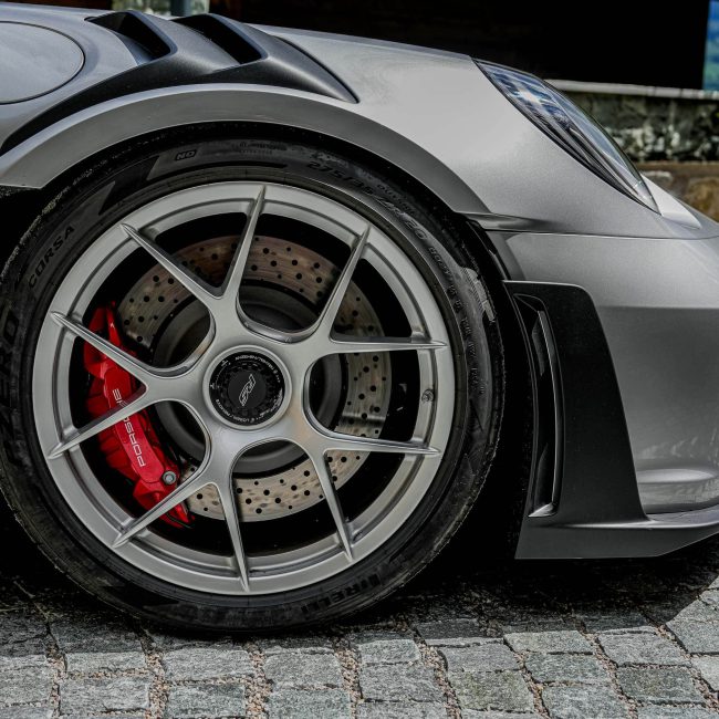 Close-up of Porsche Sports Car Alloy Wheel, Red Brake Calipers, Luxury Car Kitzbühel