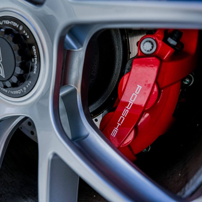 Close-up of a Silver Porsche Rim with Red Brake Caliper, Luxury Cars Kitzbühel