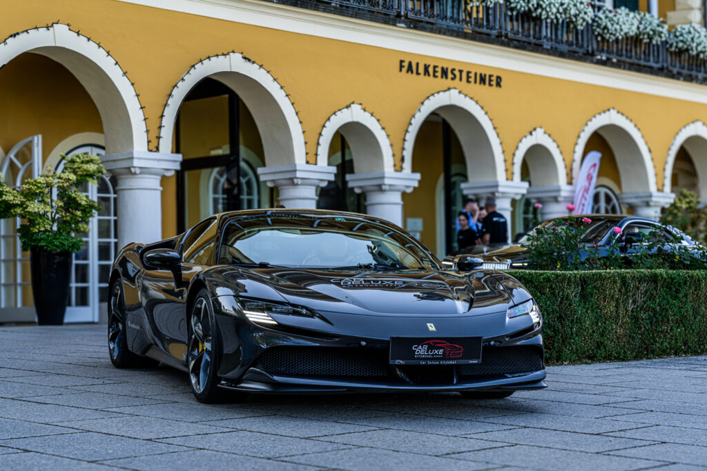 Schwarzer Sportwagen vor gelbem Gebäude mit Arkaden