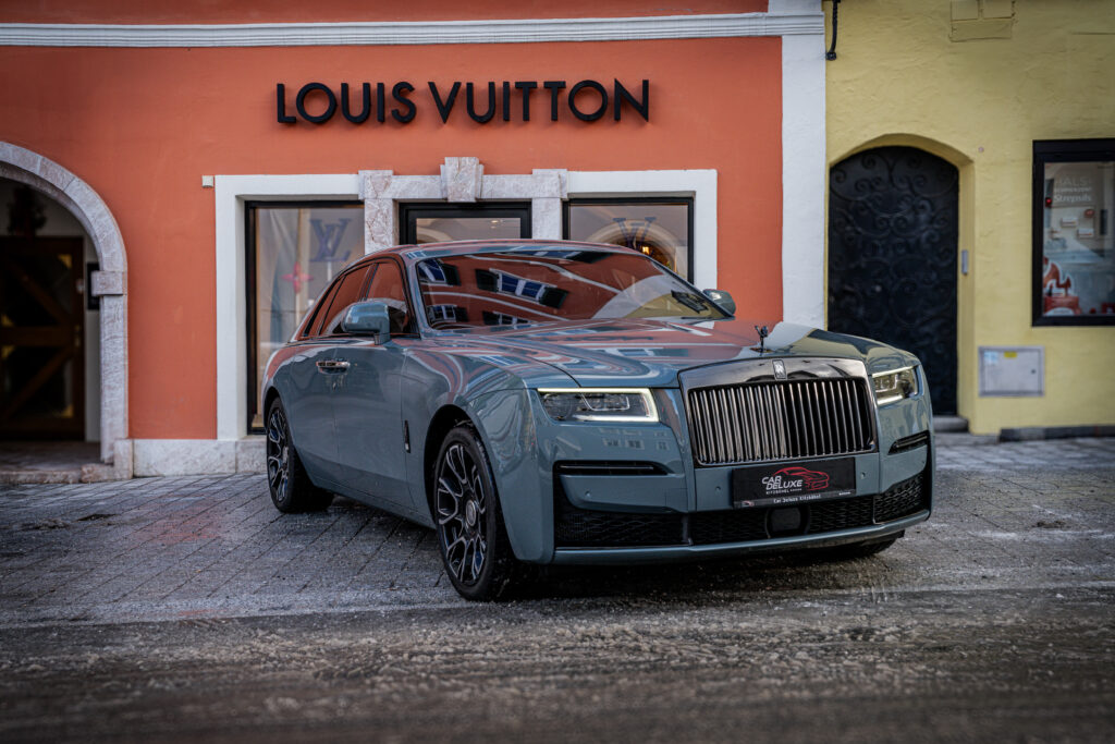 Grauer Luxuswagen vor Louis Vuitton Geschäft