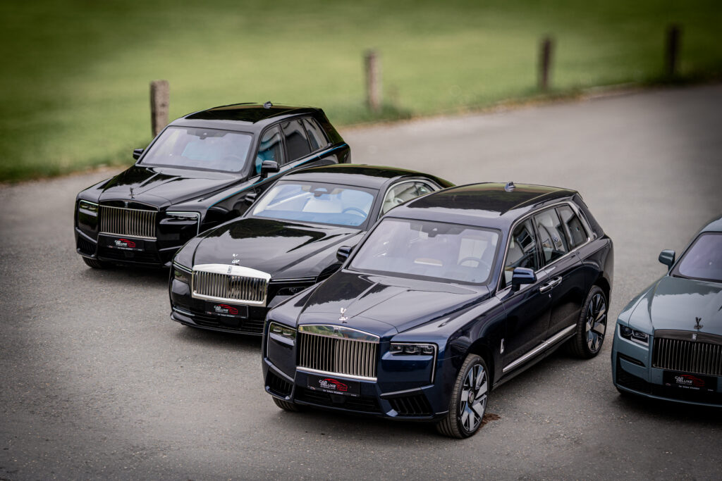 Mehrere Luxusautos stehen nebeneinander auf einer Straße